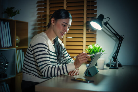 woman working with digital tablet at night - Powered by Adobe