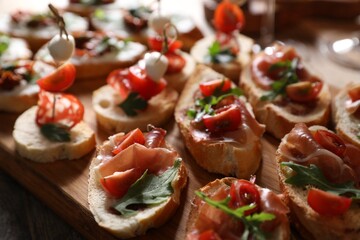 Different delicious bruschettas on wooden table, closeup