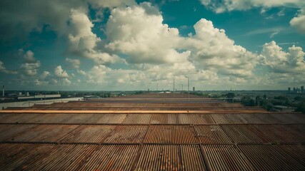 Holding camera capturing rusted corrugated metal roof in urban area to show cumulus clouds - Powered by Adobe
