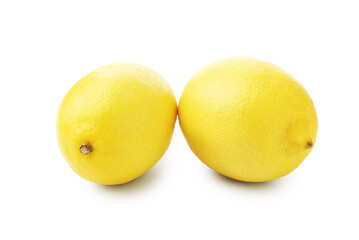 Two whole ripe lemons isolated on white