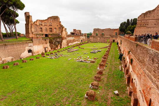 Rome, Italy - 04 November 2012: View of the Palatine Hill's ancient ruins and lush green field, where the weathered brick and stone structures stand in silent testament to history.