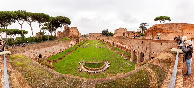 Rome, Italy - 04 November 2012: View of the ancient Circus Maximus where emerald grass meets the weathered brick ruins under a muted sky.