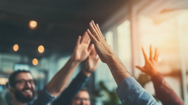 Colleagues highfiving, celebrating business success in modern sunlit office, embodying effective team collaboration.