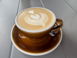 Fragrant cappuccino in the cup on the table in a cafe, close up