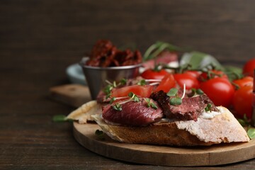 Delicious bruschettas with roast beef served on wooden table, closeup. Space for text