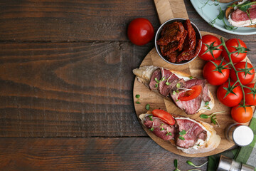 Delicious bruschettas with roast beef served on wooden table, flat lay. Space for text