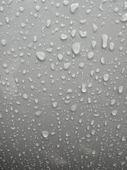Vertical view of drops of water on a gray background. Rainy season concept