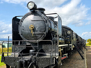 Black metal steam train and rail track in the outdoor history museum