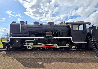 Black metal steam train and rail track in the outdoor history museum