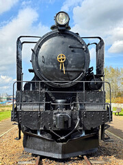 Black metal steam train and rail track in the outdoor history museum