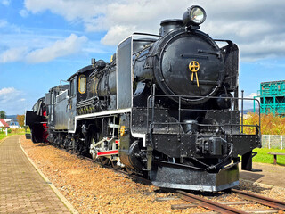 Black metal steam train and rail track in the outdoor history museum
