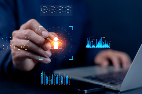 Businessman using laptop with digital target audience and data analytics hologram, representing customer insight, marketing strategy, and business intelligence in digital technology. - Powered by Adobe