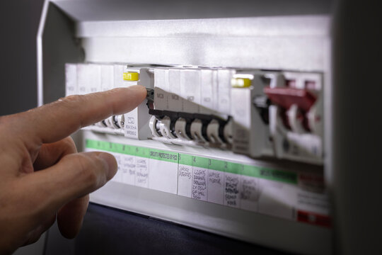 Electricity power outage emergency turning on or off circuit breaker on electrical fuse board