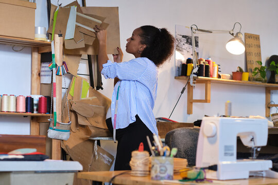 side view of a Pregnant black woman working in her sustainable fashion design workshop