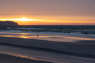 Sunset light over coastal beach. Golden hour at the seaside.
