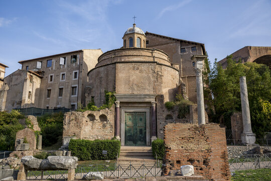 View of the ancient Temple of Romulus stands in striking contrast to the modern buildings under a clear sky, Rome, Lazio, Italy.