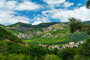 hotels of the resort town against the backdrop of mountains covered with forest, architecture, Petrovac city, Montenegro
