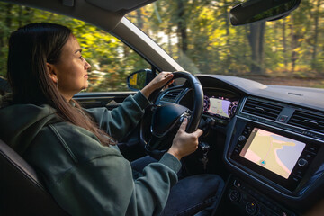 Woman driving car with GPS. Autumn nature travel.