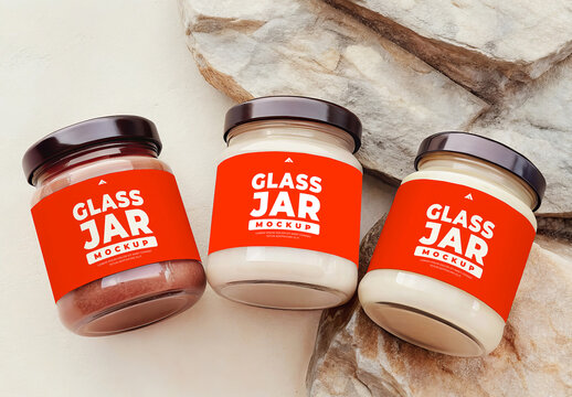 Set of Three Small Glass Jars Mockups with Lids on Rustic Wood and Rock Surface