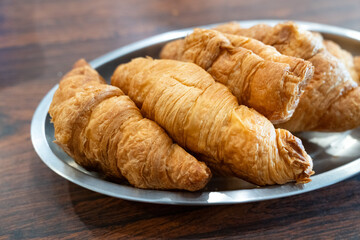 Freshly baked croissants on a metal plate