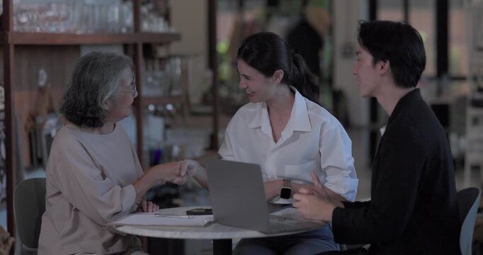 An Asian male investor and team meet with senior female owner at family business ceramic retail shop, negotiating and signing a partnership contract to expand retail and wholesale opportunities.
