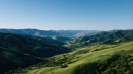 Fototapeta premium Scenic Sweeping View of Lush Green Rolling Hills and Open Terrain Under Clear Blue Sky