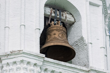 Obraz premium Close-up of big brass bell in the white belfry of Epiphany Cathedral in Yeniseysk, Russia.