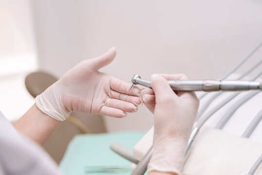 Close up of Dentist hands preparing dental drill for operating a patient in a dental clinic