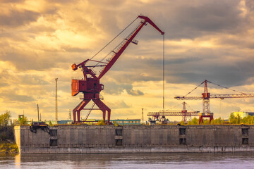 Evening view on red gantry crane at the Lesosibirsk river port on the Yenisei River, Russia. Industrial background