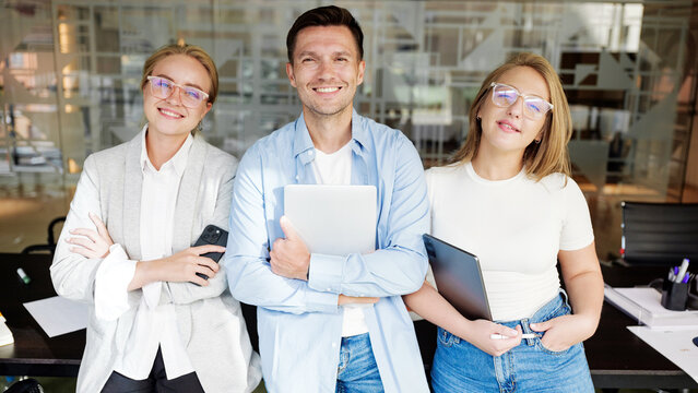 Team of young professionals posing in office