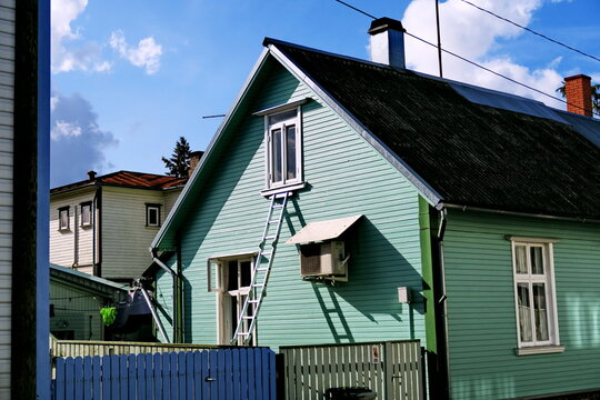 Echelle pos&eacute;e devant la fen&ecirc;tre du premier &eacute;tage d'une maison en bois.