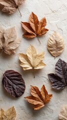 Fototapeta premium Colorful dried autumn leaves creating a beautiful pattern on a textured beige background, capturing the essence of fall and the changing seasons
