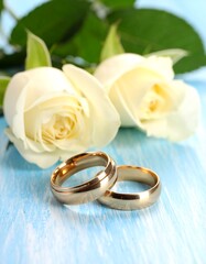 Close-up shot of wedding rings with two white roses