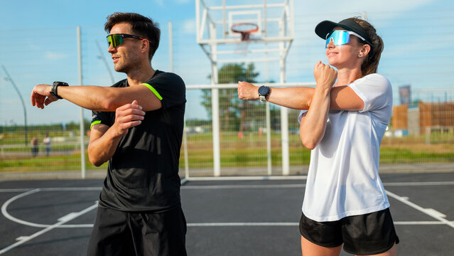 Couple stretches together before basketball game