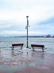 Two lonely benches on a pier in winter
