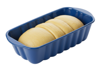 Isolated bread dough, uncooked, resting in a grooved blue baking pan, ready for the oven