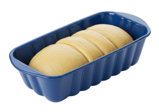 Isolated bread dough, uncooked, resting in a grooved blue baking pan, ready for the oven