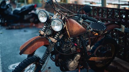 Close up of a vintage rusty motorcycle parked on a city street