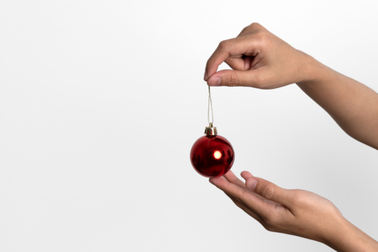 hand holding red christmas ball on white background