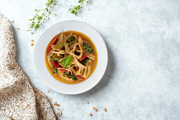 Hearty vegetable noodle soup in a white bowl with herbs