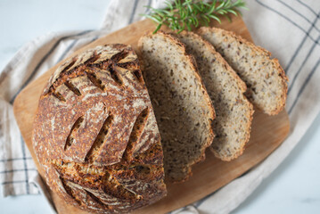 Freshly baked round bread with a golden crust on wooden shelf