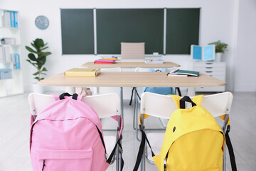 Green chalkboard and stylish furniture in classroom. Mockup for design
