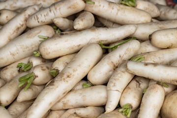 A pile of white vegetables with green leaves