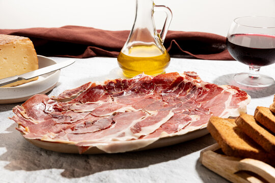 Serrano ham plate and cheese with a glass of whine, mediterranean appetizer.