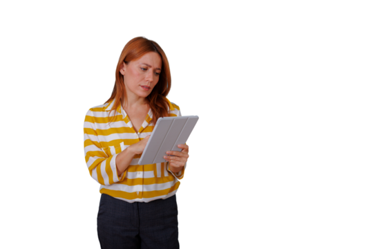 Focused professional woman with red hair working on a touchscreen tablet. Business innovation and technology concept. Transparent background - Powered by Adobe