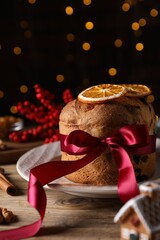Christmas food. Delicious Panettone cake, ingredients and festive decor on wooden table against...