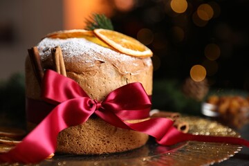 Christmas food. Delicious Panettone cake, spices and festive decor on table against background with...