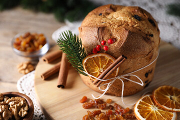 Christmas food. Delicious Panettone cake, ingredients and festive decor on table, closeup