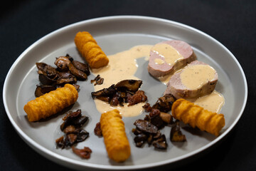 gebratenes Schweinefilet mit Waldpilzen, Kroketten und Sahnesoße