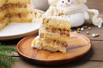 Piece of delicious cake with Christmas decor on wooden table, closeup